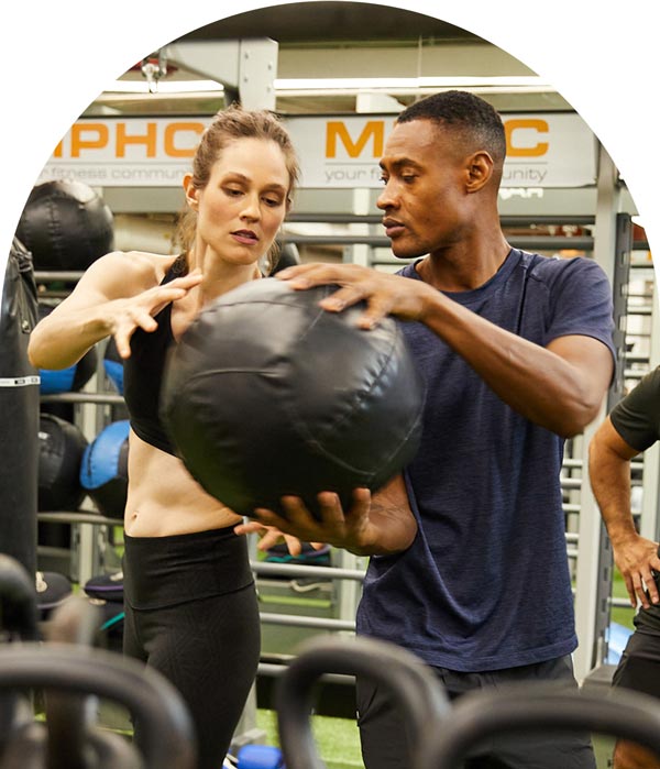 Personal Trainers Working With Medicine Ball at Fitness Center